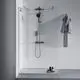 Duschsystem von Ideal Standard mit Glasabtrennung, Kopf- und Handbrause, sowie einem Handtuchhalter. Ablagefläche mit Pflegeprodukten neben der Dusche sichtbar.
